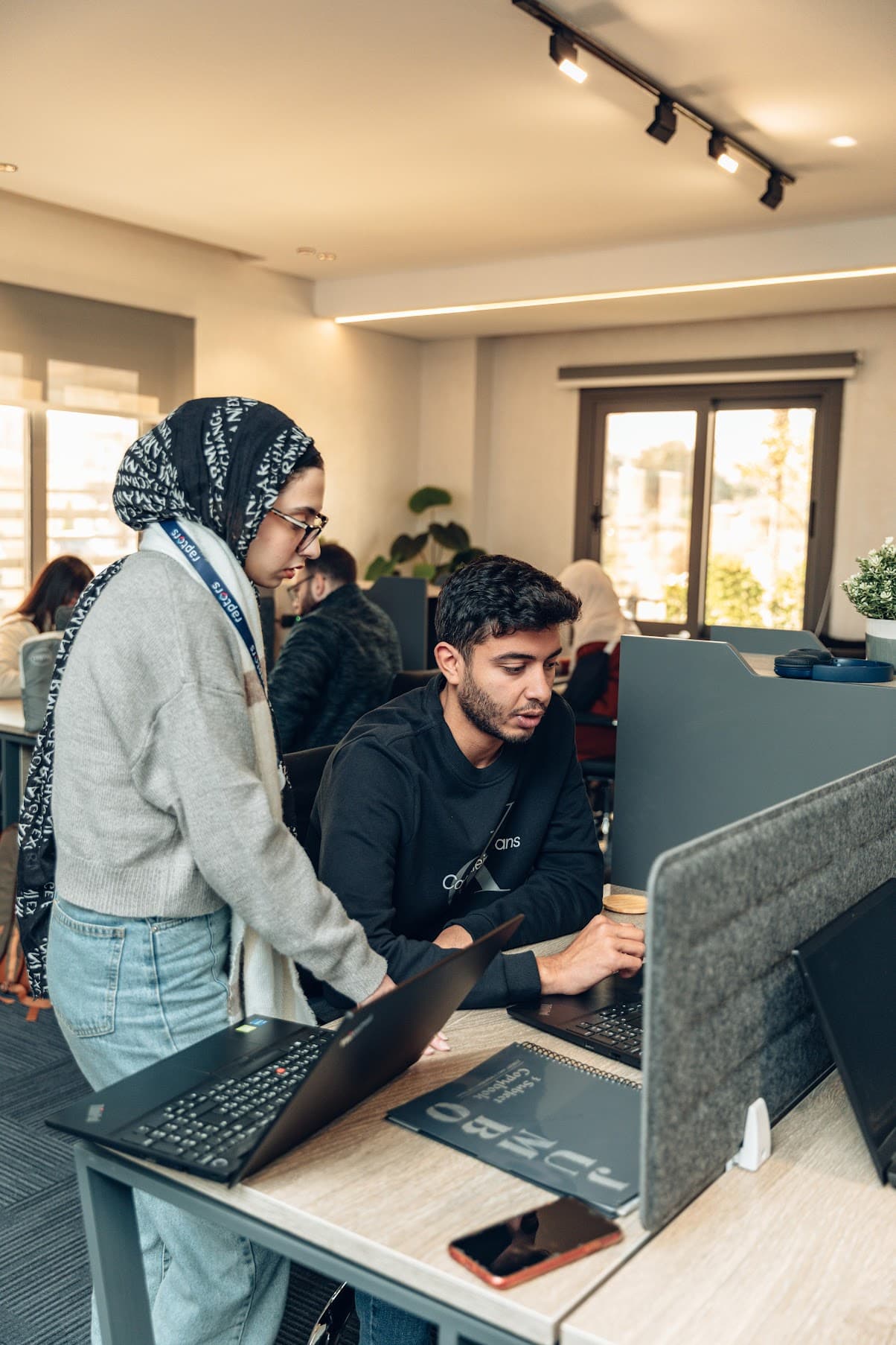 Two consultants reviewing work together at a Cairo desk.