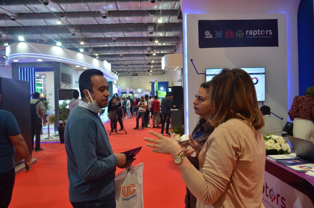 A consultant explaining the product to a visitor at the stand.